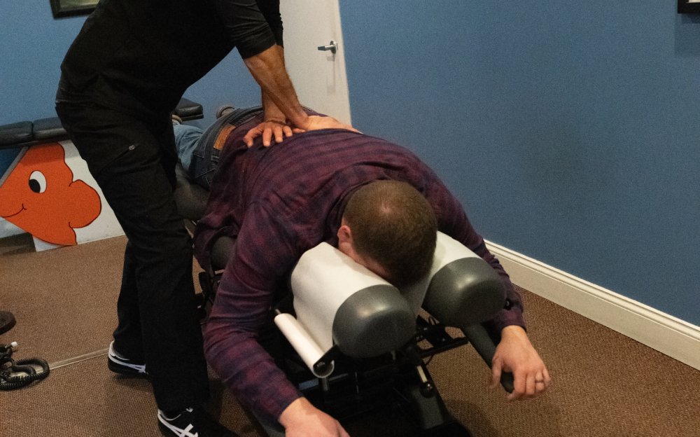Dr. Posada performing a gentle chiropractic adjustment at CoreNeuro in Portage, MI