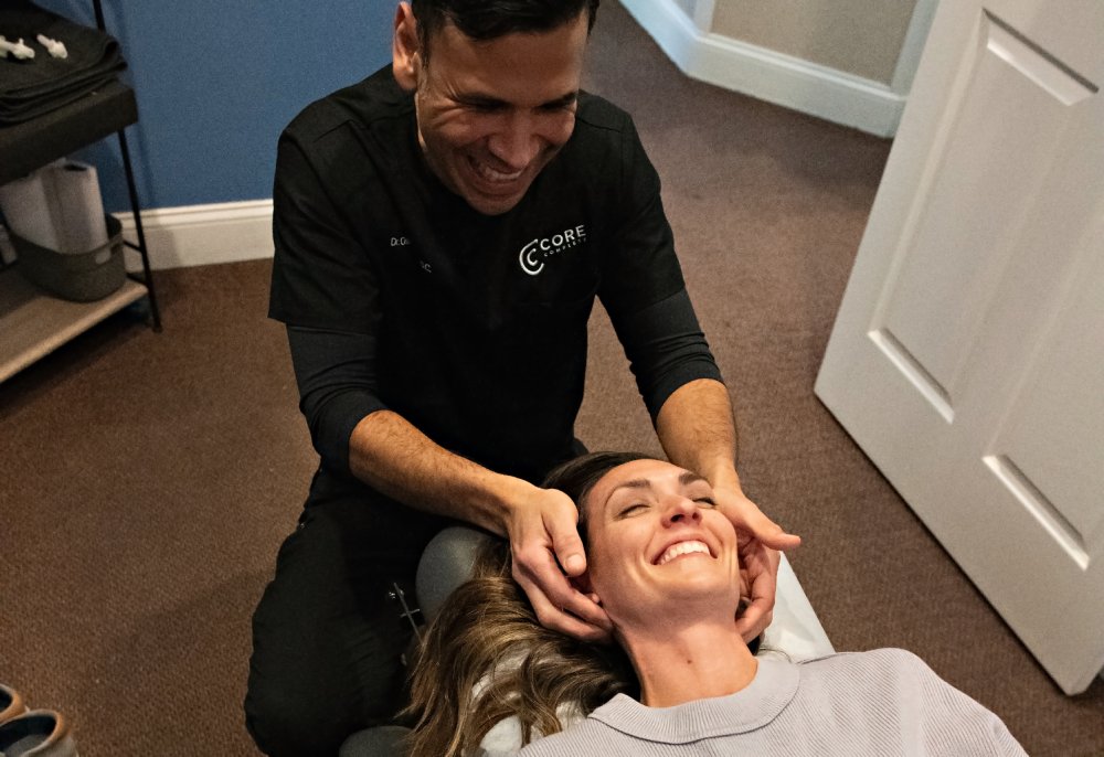 Dr. Posada performing a gentle adjustment on a smiling patient