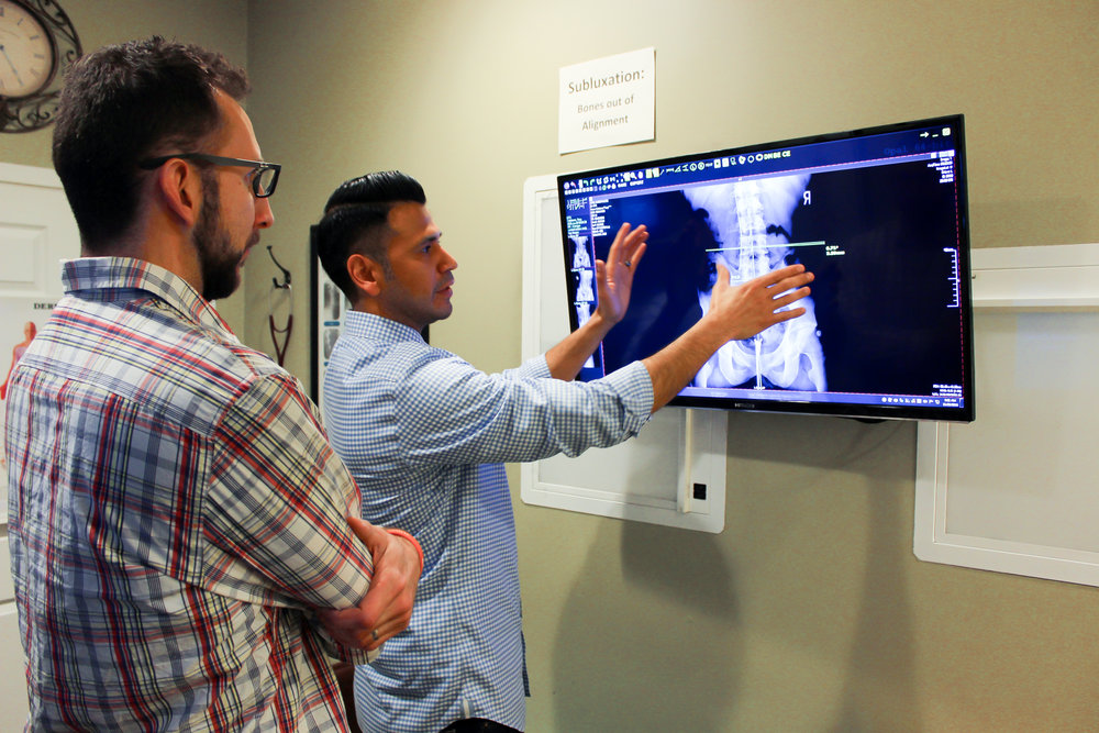 Dr. Posada reviewing a spinal X-ray with a patient